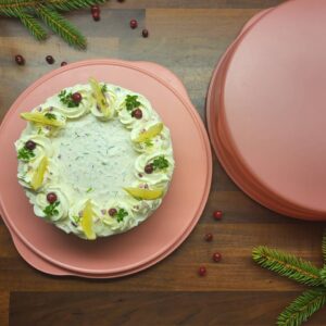 ümmargune soolane tort kalaga, kaunistuseks toorjuusturoosid, sidrun ja jõhvikad. jõuluteemalisel taustal