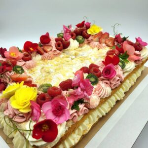 kandiline brita tort, roosa kaunistusega, kaunistuseks kasutatud toorjuustukreemi, marju, lilli ja kuldset söödavat glitterit