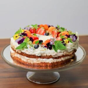 ümmargune brita tort, kaunistuseks värsked aprikoosid, vaarikalehed, lilled ja marjad