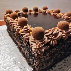 kandiline, rohke šokolaadi kaunistusega tort. kaunistuses šokolaadi lisaks sokolaadikommid ja nonparellid