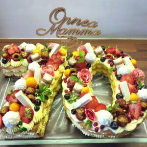 suur küpsise tort juubeliks, tordi kujuks numbrid 7 ja 0. kaunistuseks rohkelt lillli, marjua ja küpsiseid.