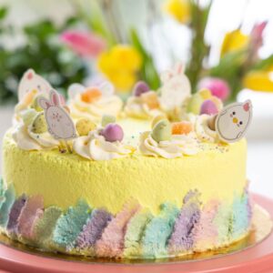 ümmargune, kollane lihavõtetort. kaunistus värviline kreem ja lihavõttemuna kommid, paberist tibud